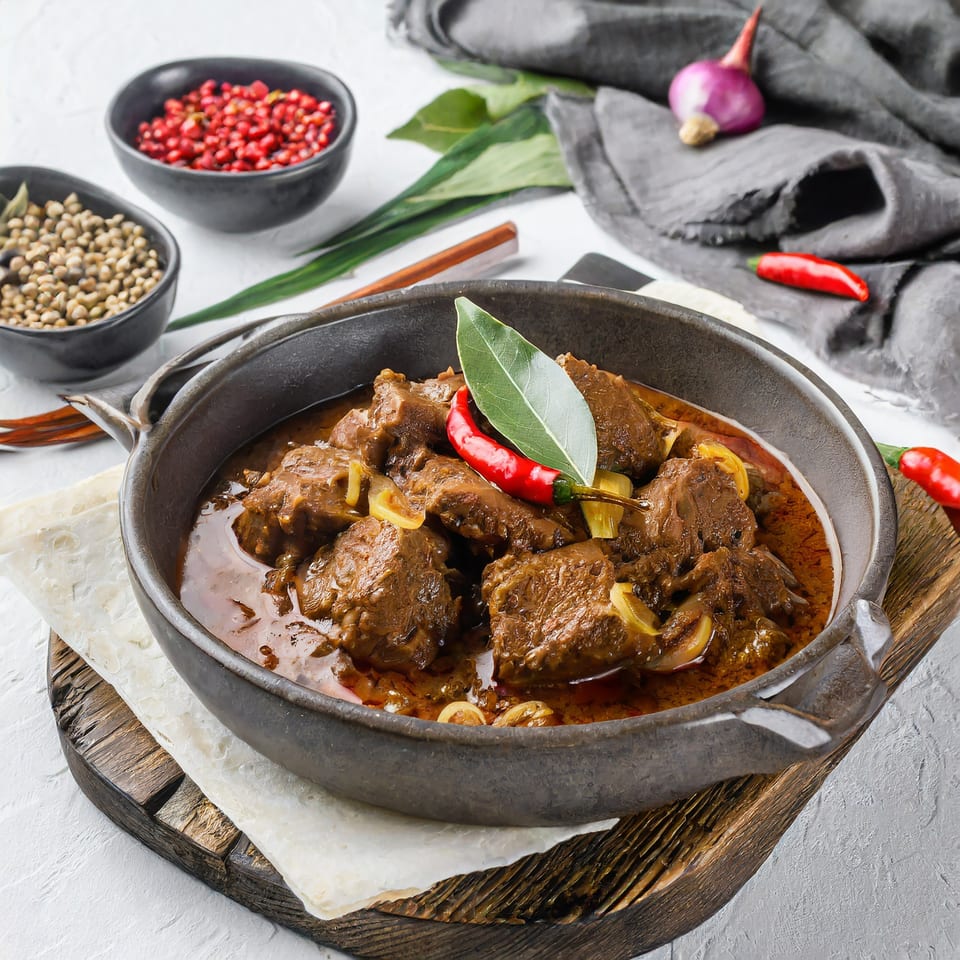 Tikka and Grill's Indian beef curry, garnished with bay leaf and chili, served with flatbread.